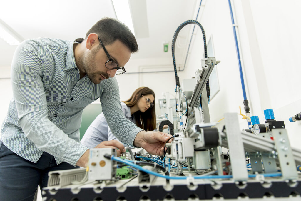 Young couple of students working at robotics lab